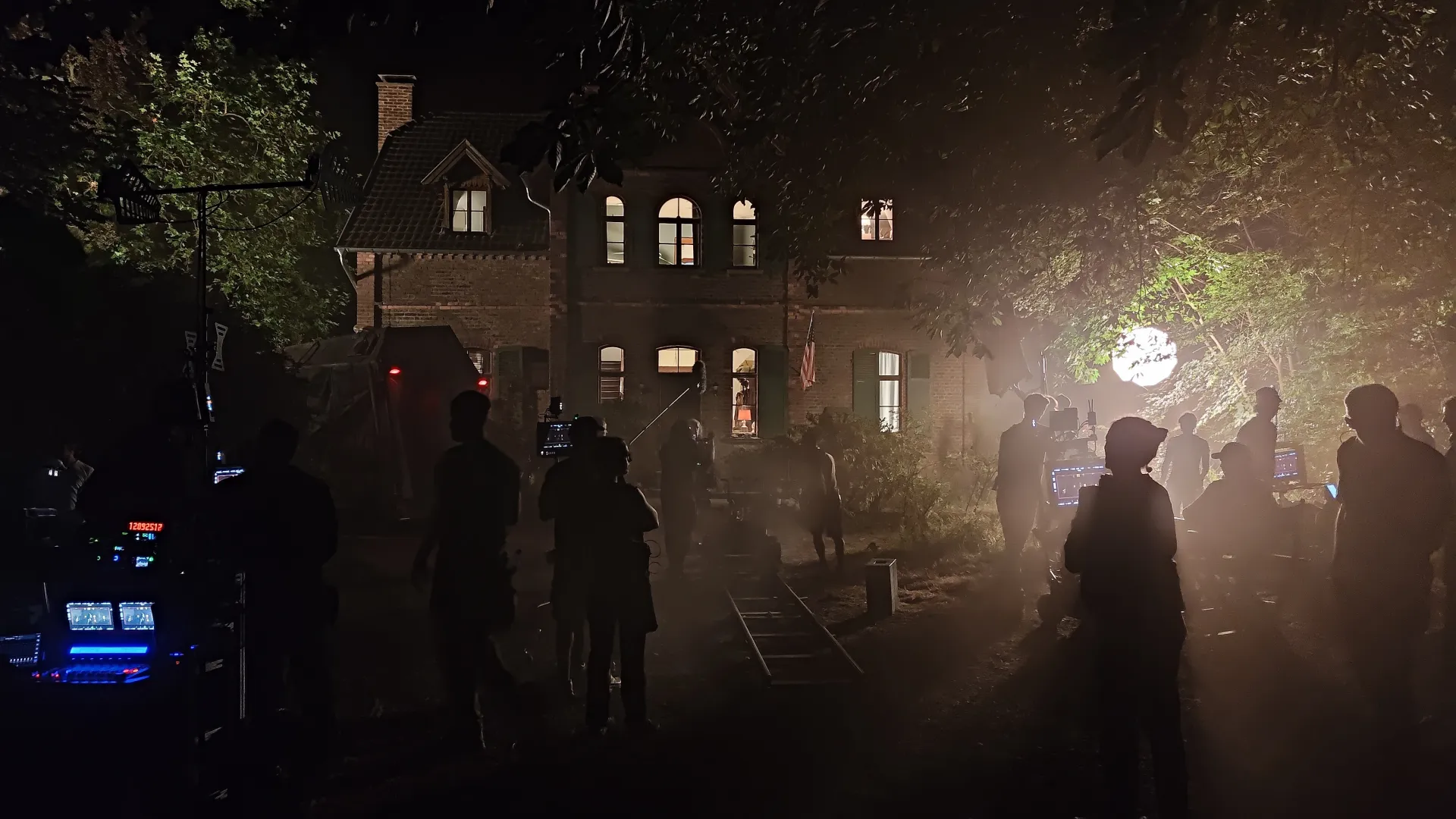 Nachtdreh vor einem alten Backsteinhaus, Crew-Silhouetten im Kunstnebel